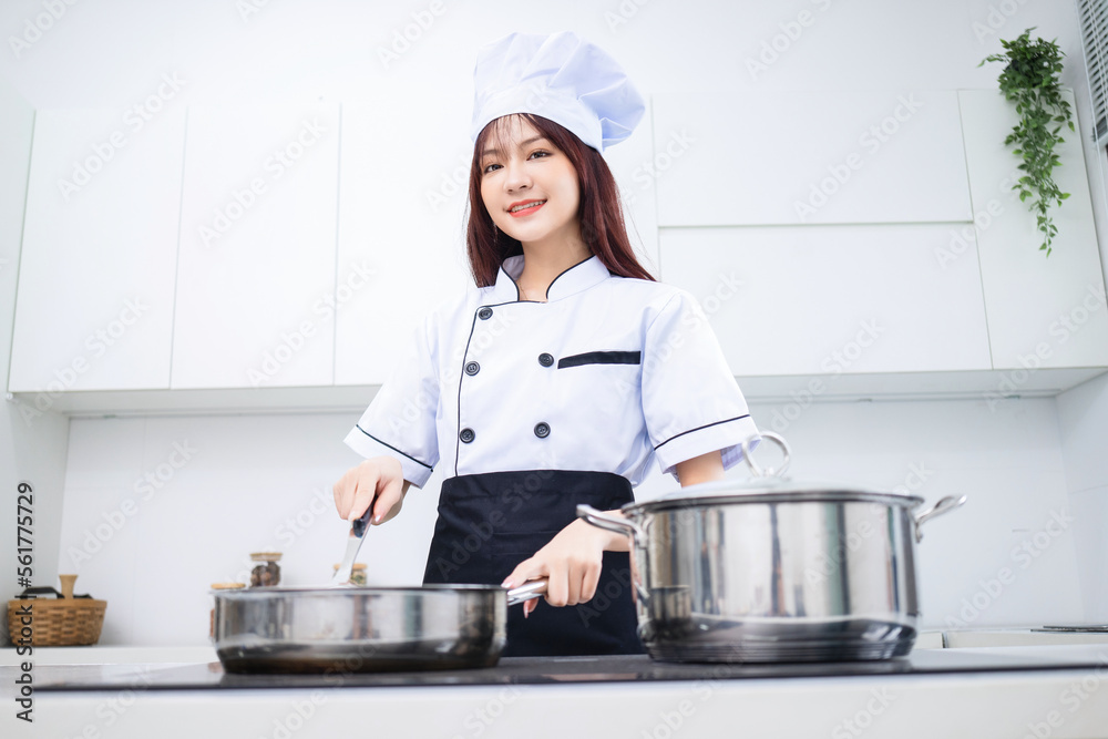 Image of young Asian woman chef in the kitchen