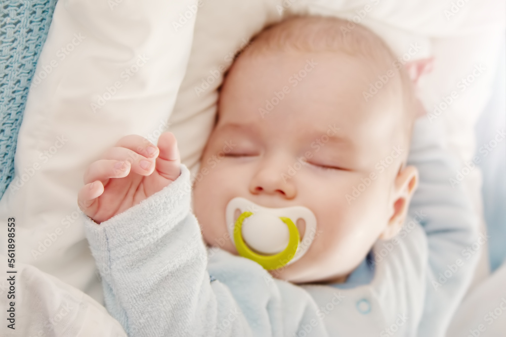 Cute three month old baby sleeping in comfortable bed.