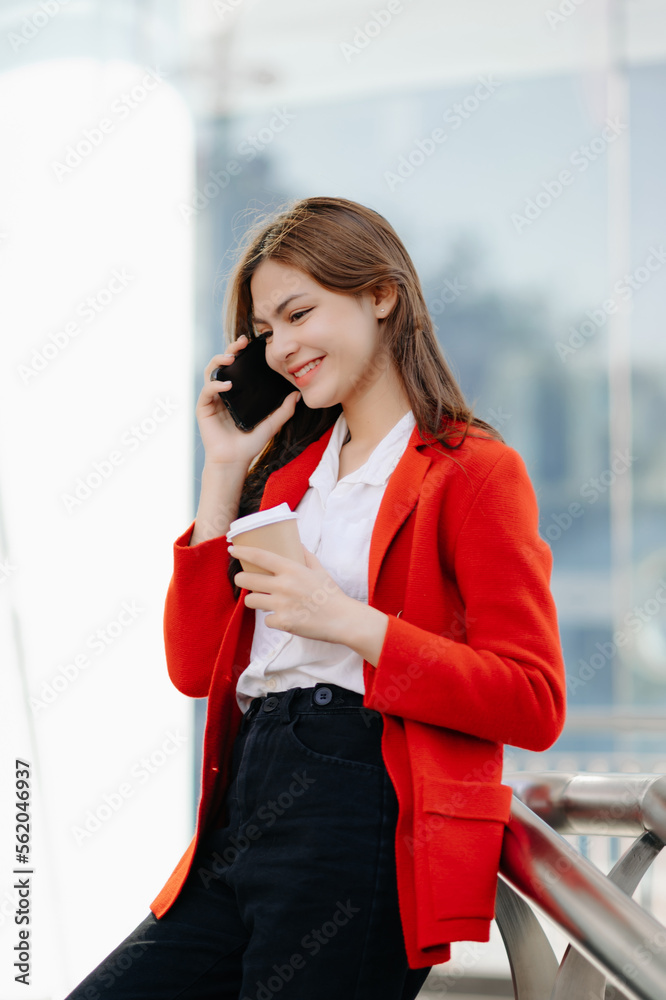 Beautiful female businesswoman use smartphone and holding laptop computer, Walk enjoy smiling while 