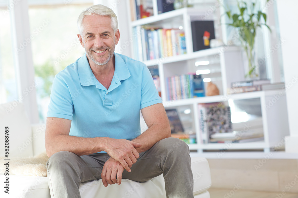 Senior man, sitting and smile in living room relaxing at home on sofa enjoying happy retirement. Por