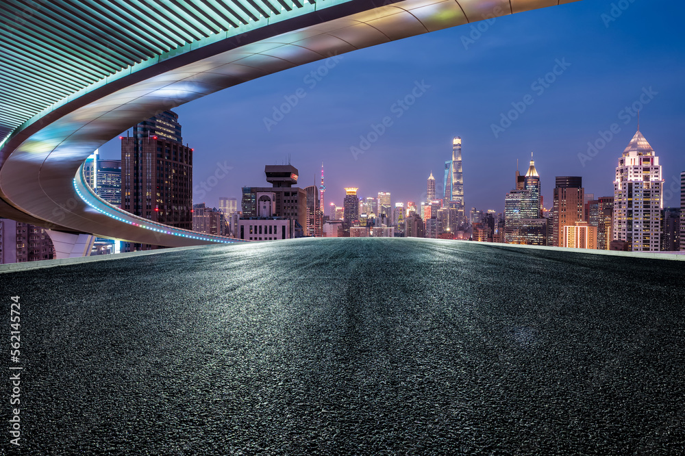 Asphalt road and bridge with city skyline at sunset in Shanghai, China.