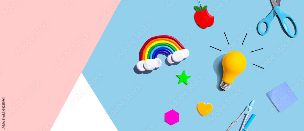 Idea light bulb with a rainbow and school supplies - flat lay