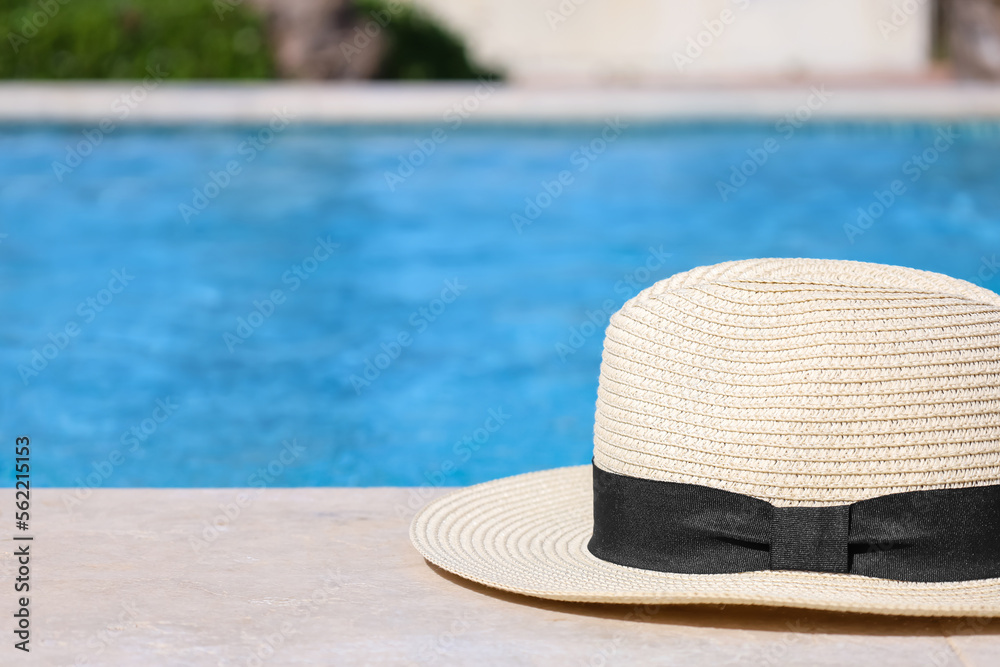 Summer hat on edge of swimming pool, closeup