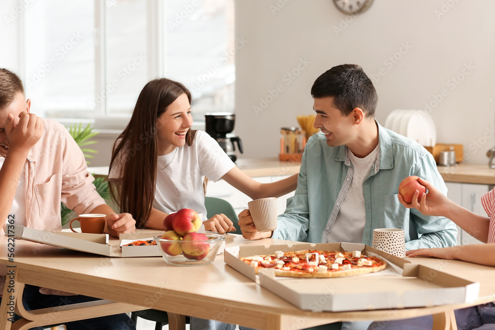 Group of friends spending time together at table in kitchen