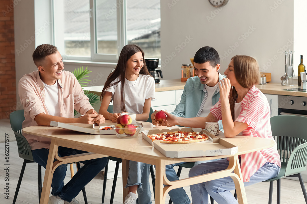 Group of friends spending time together at table in kitchen