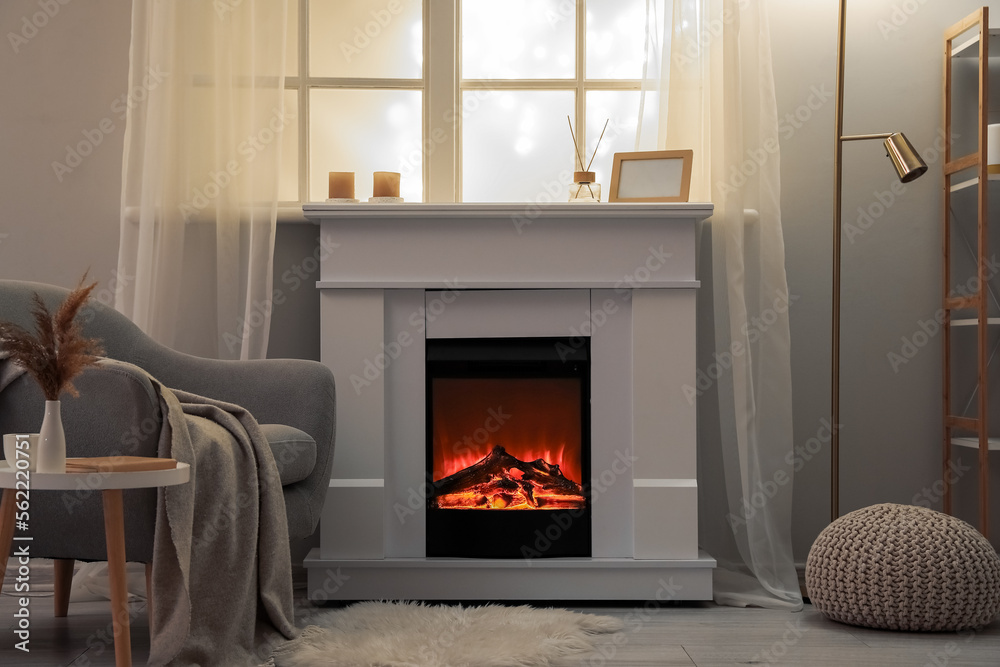 Interior of modern living room with electric fireplace and armchair