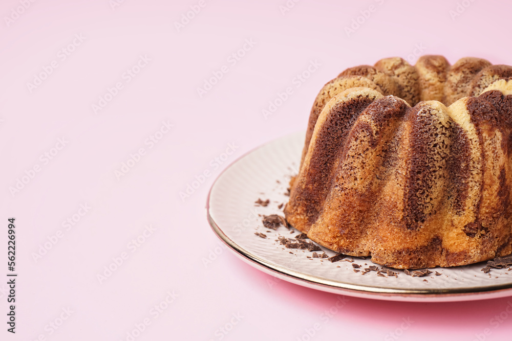 Plate with delicious cake on pink background