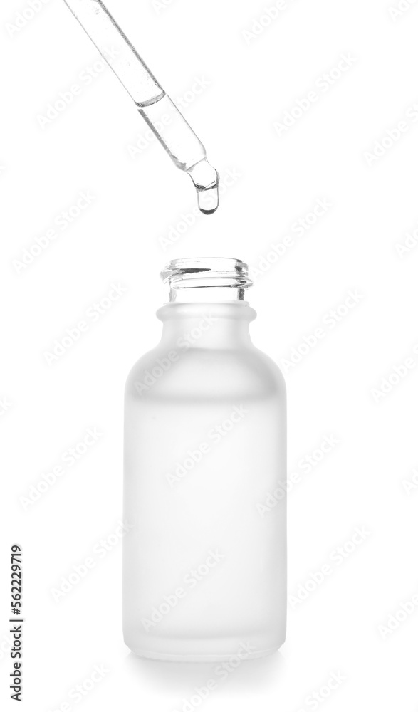 Dripping of serum from pipette into bottle on white background