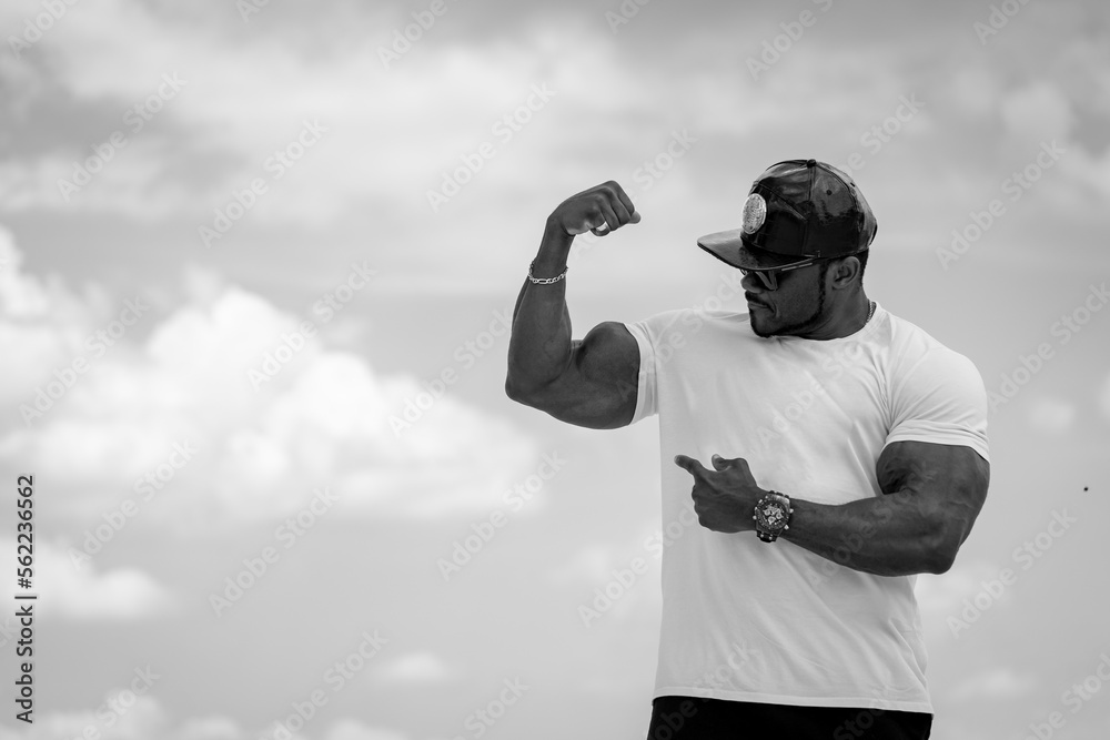 Strong muscular man showing his muscles. Black and white shot of bodybuilder.