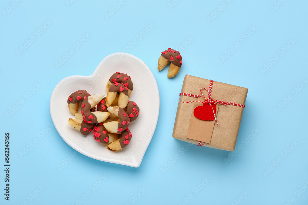 Plate of fortune cookies with gift on blue background. Valentines Day celebration