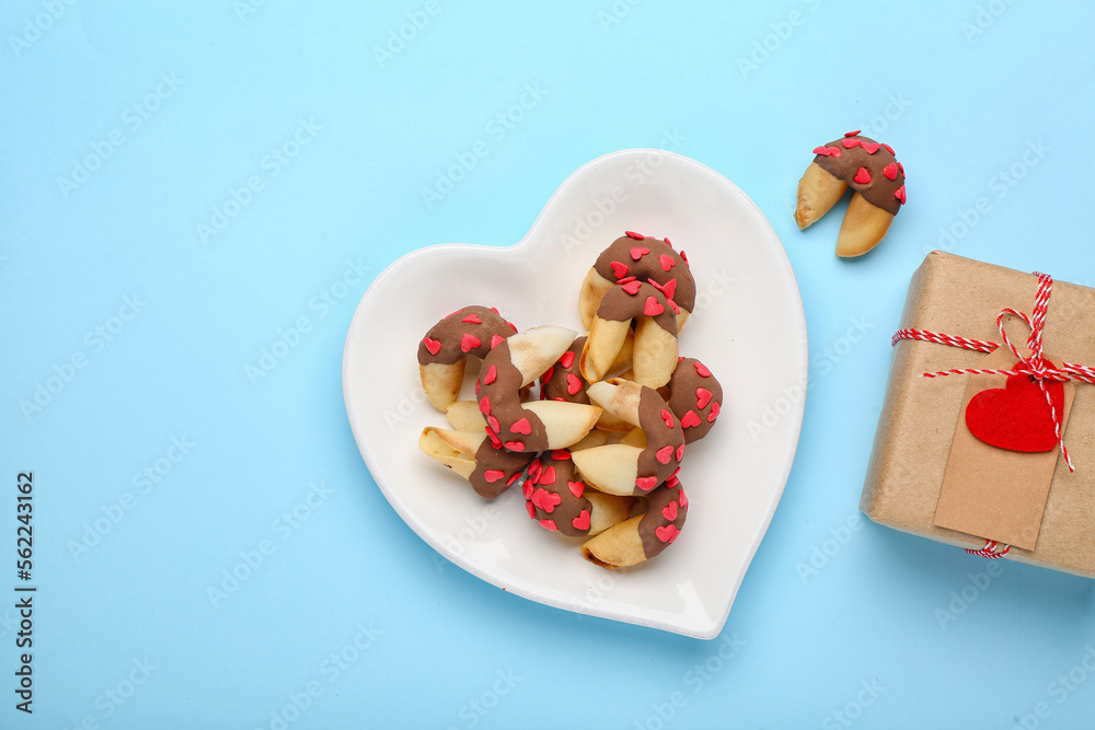 Plate of fortune cookies with gift on blue background. Valentines Day celebration