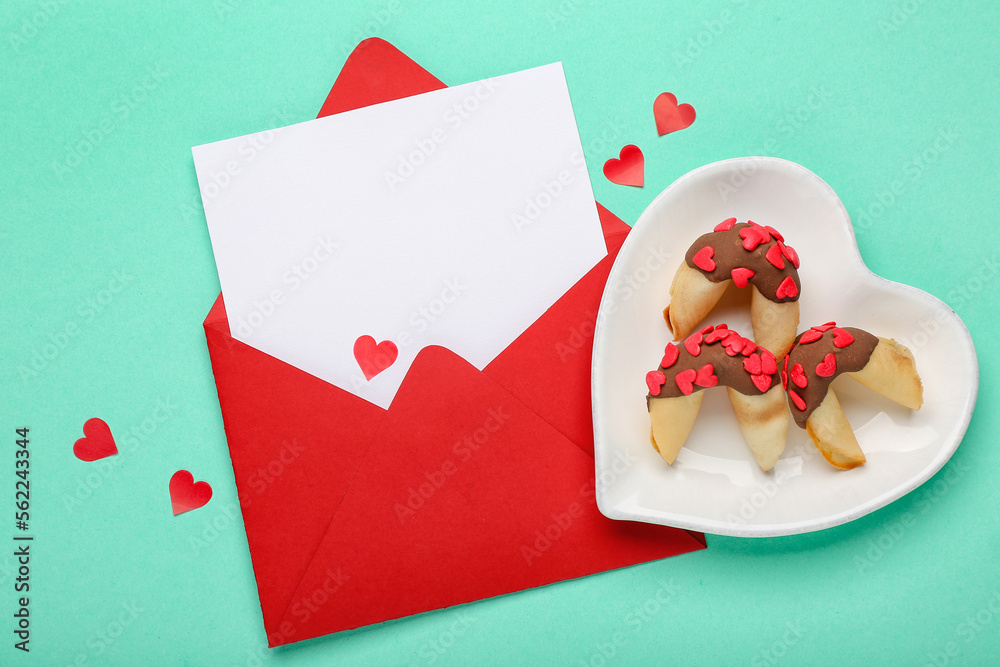 Plate of fortune cookies and envelope on green background. Valentines Day celebration