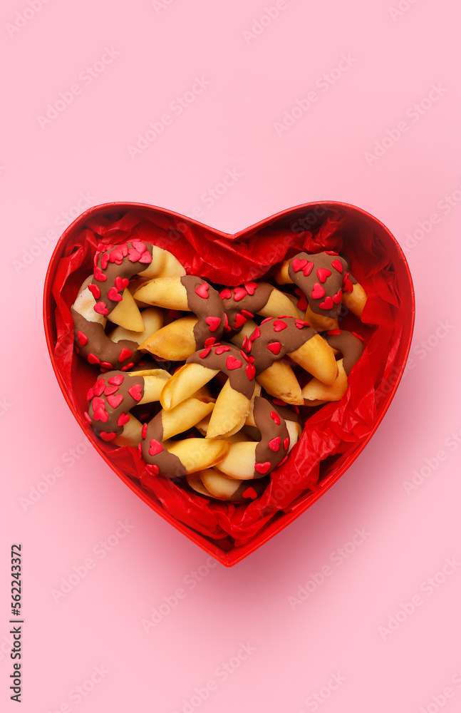 Heart-shaped gift box with fortune cookies on pink background. Valentines Day celebration