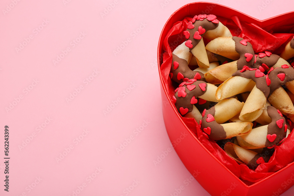 Heart-shaped gift box with fortune cookies on pink background, closeup. Valentines Day celebration