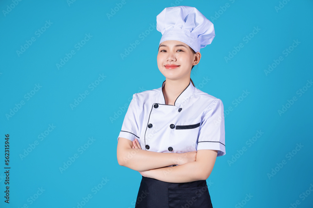 Portrait of young Asian female chef on background