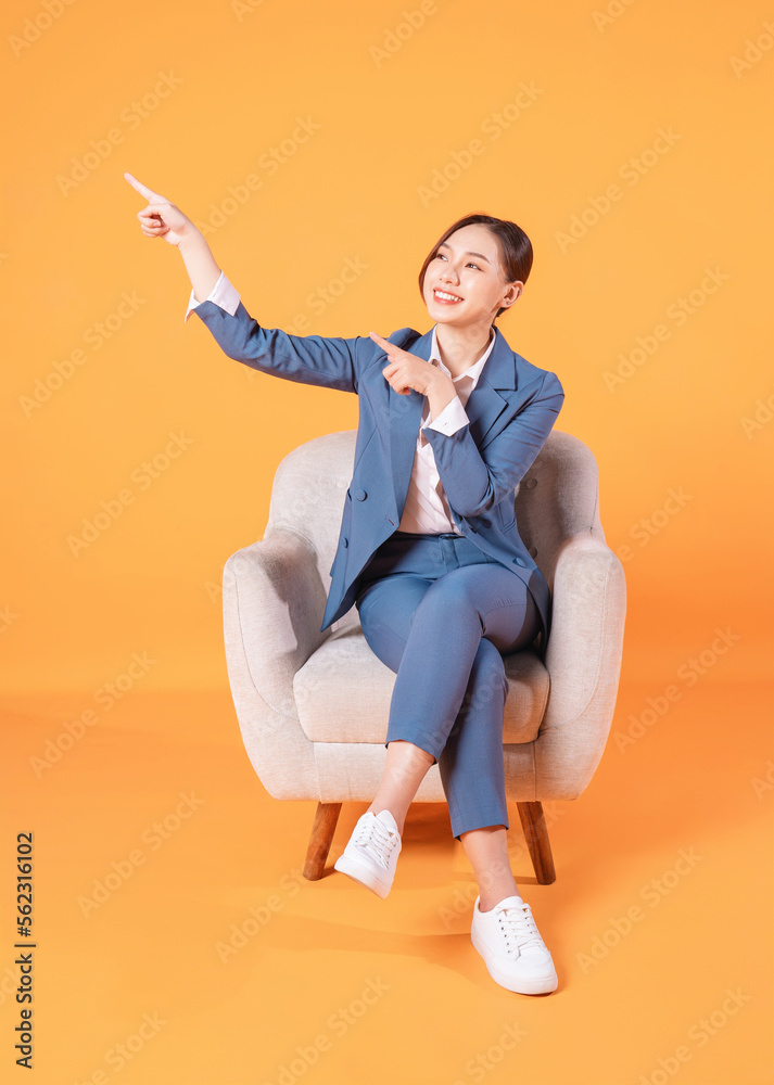 Photo of young Asian businesswoman sitting on armchair