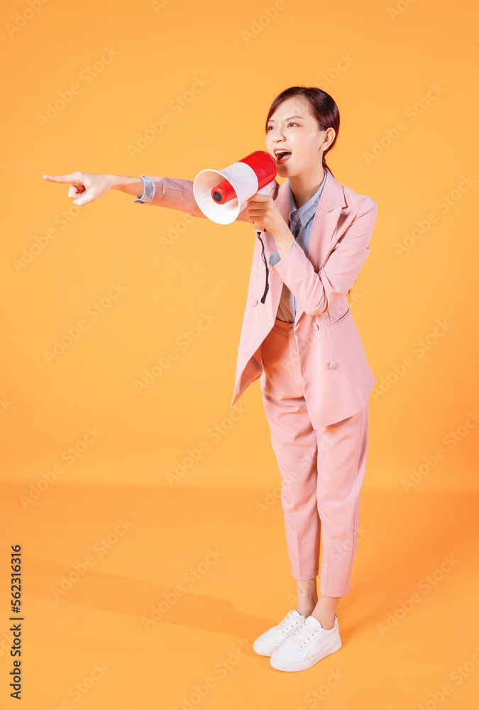 Photo of young Asian businesswoman holding megaphone on background