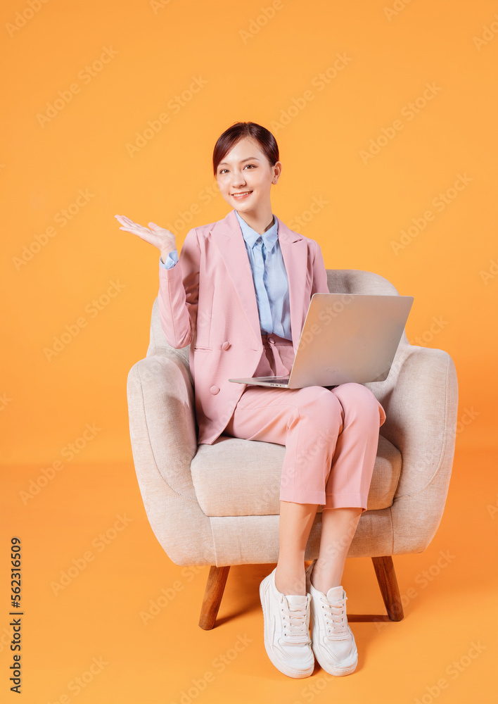 Young Asian businesswoman using laptop on background