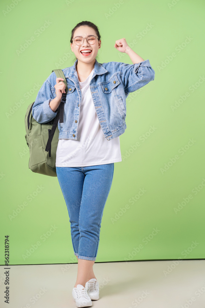 Photo of young Asian college girl on green background