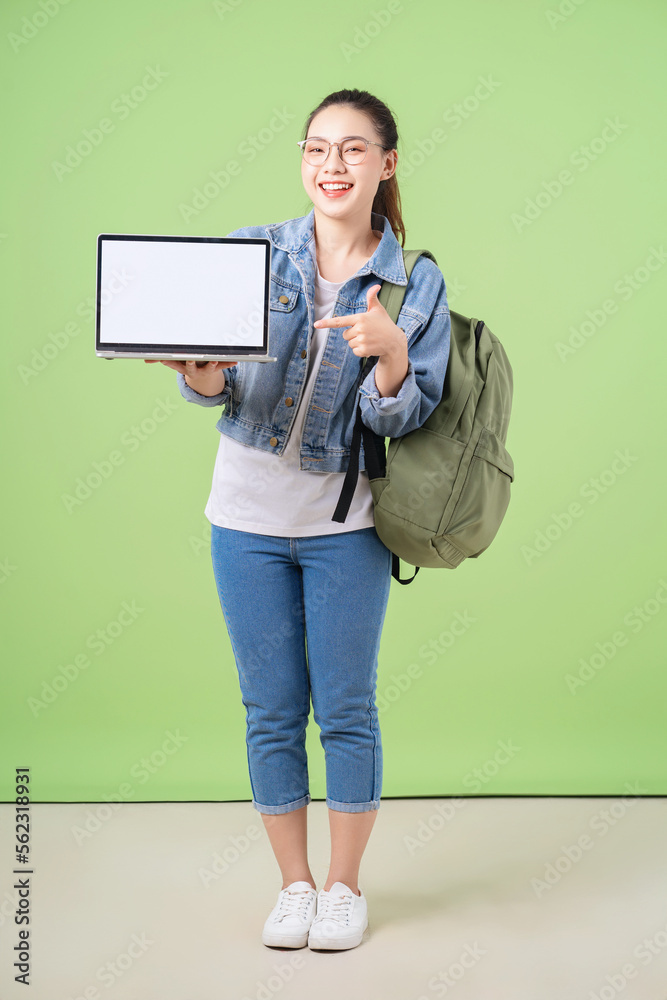 绿色背景下的年轻亚洲大学女生照片