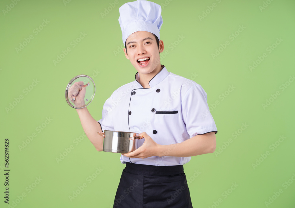 Photo of young Asian male chef on background