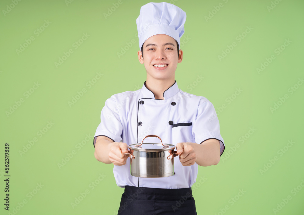 Photo of young Asian male chef on background