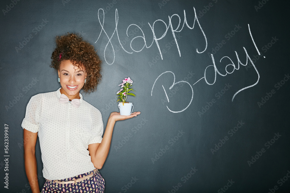 Black woman, studio portrait and holding plant with smile, beauty and celebration of birthday. Woman