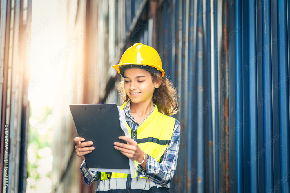 Women Engineer wears PPE checking container storage with cargo container background at sunset. Logis