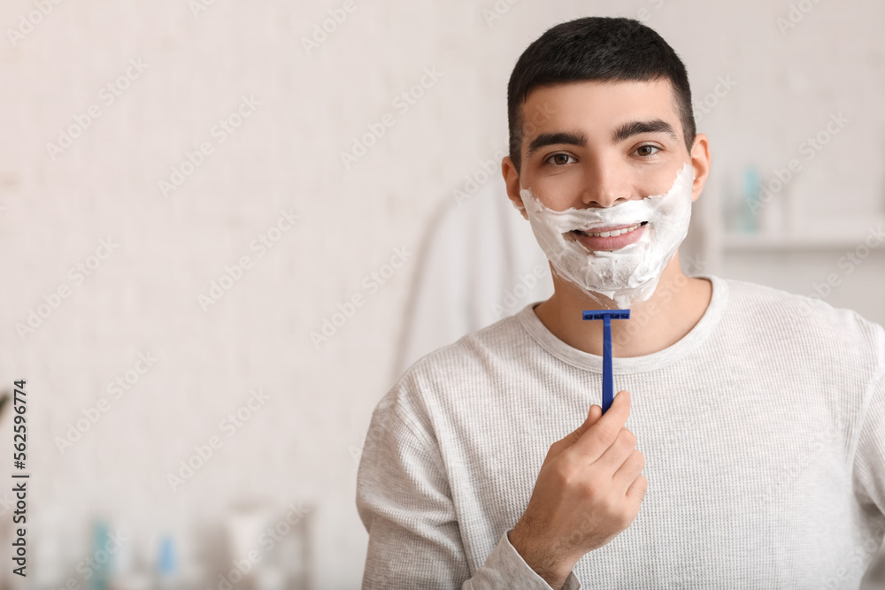 Morning of young man shaving in bathroom