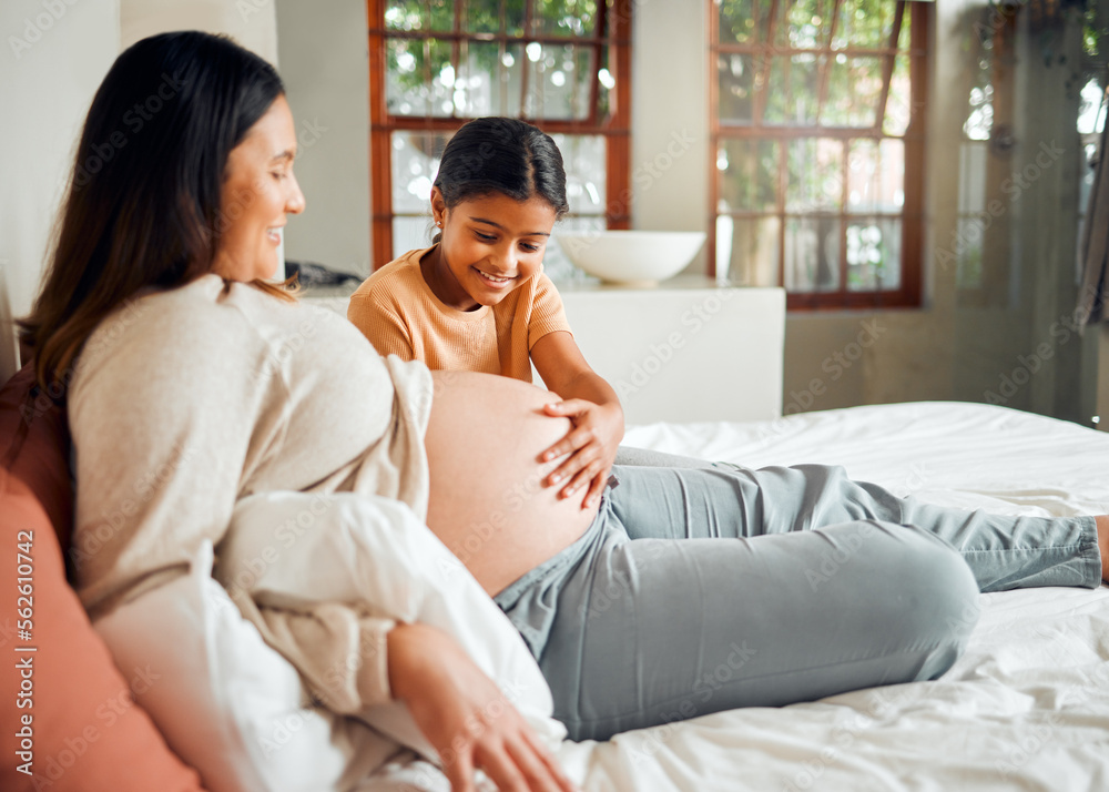 Pregnant mom and curious child on bed touching belly with excited, happy and joyful smile. Indian fa