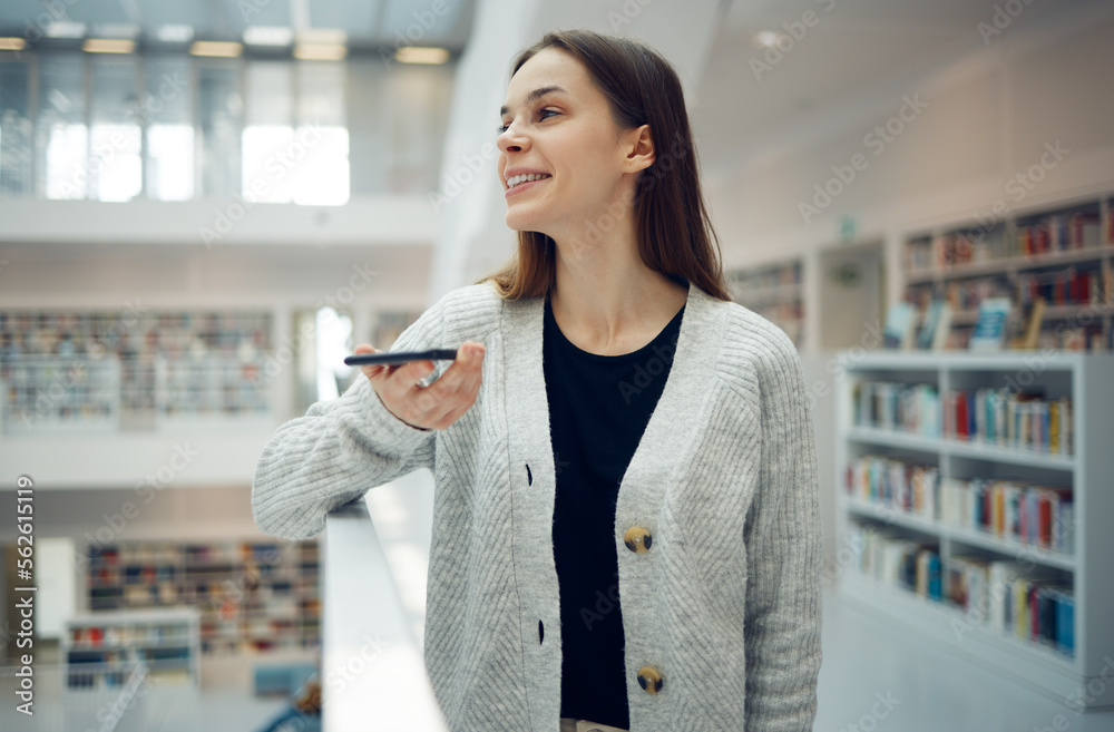 Phone, library and university woman in a education and learning building with a mobile talking. Book