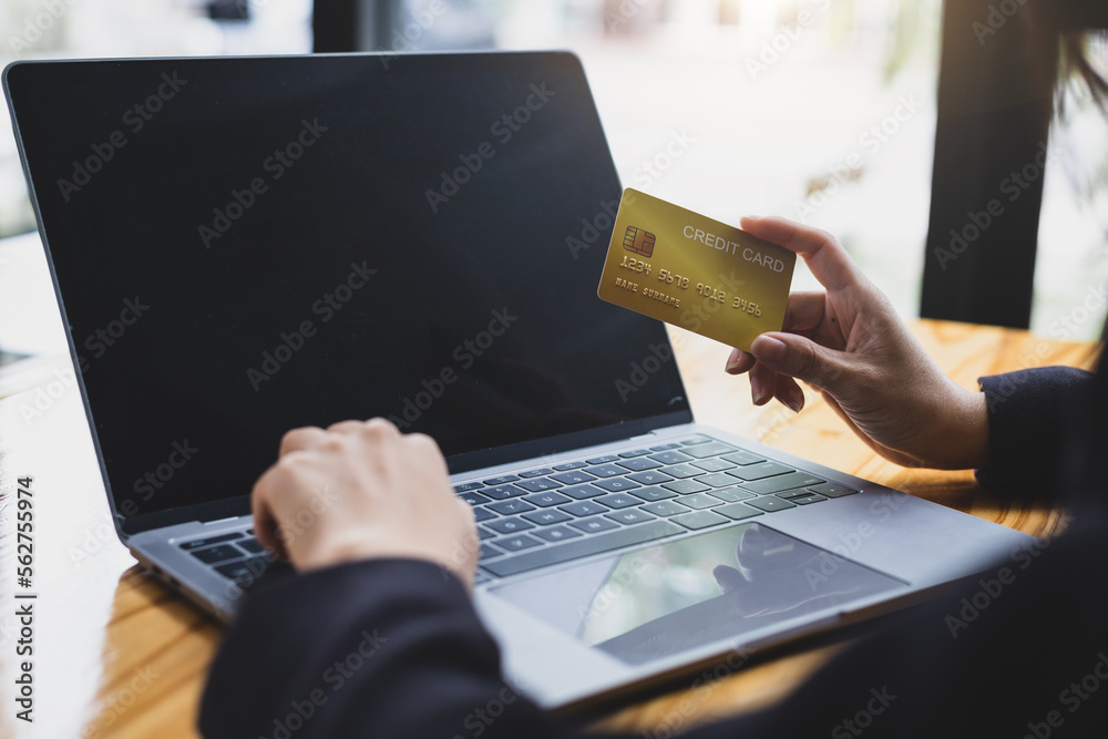 Woman holding credit card and using laptop. Online payment and online  shopping concept.