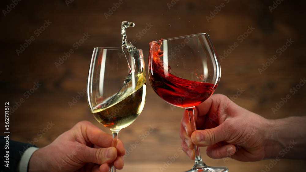 Two men clinking with glasses of wine, celebrating success.