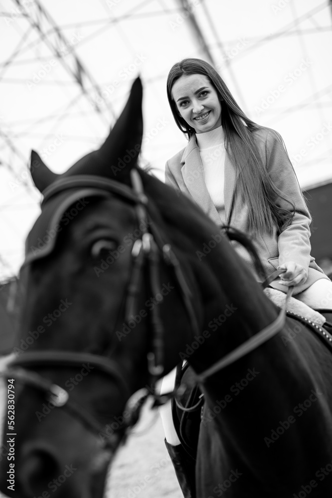 Young lady learning to ride at the ranch. Pretty jockey practice horseriding.