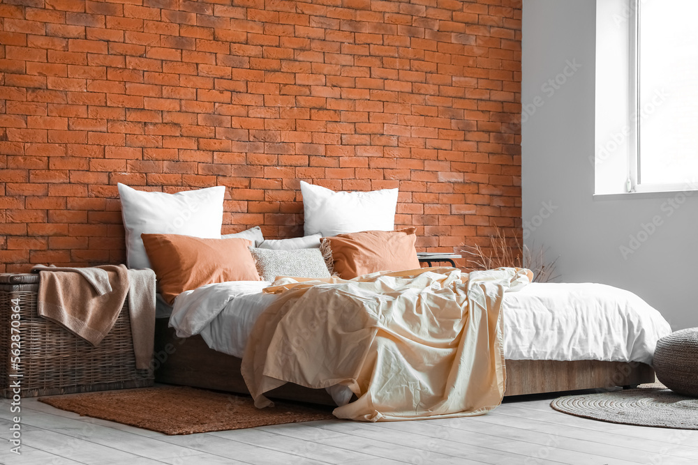 Interior of bedroom with big bed, table and basket