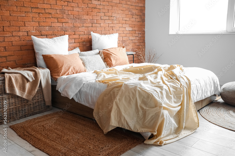 Interior of bedroom with big bed, table and basket