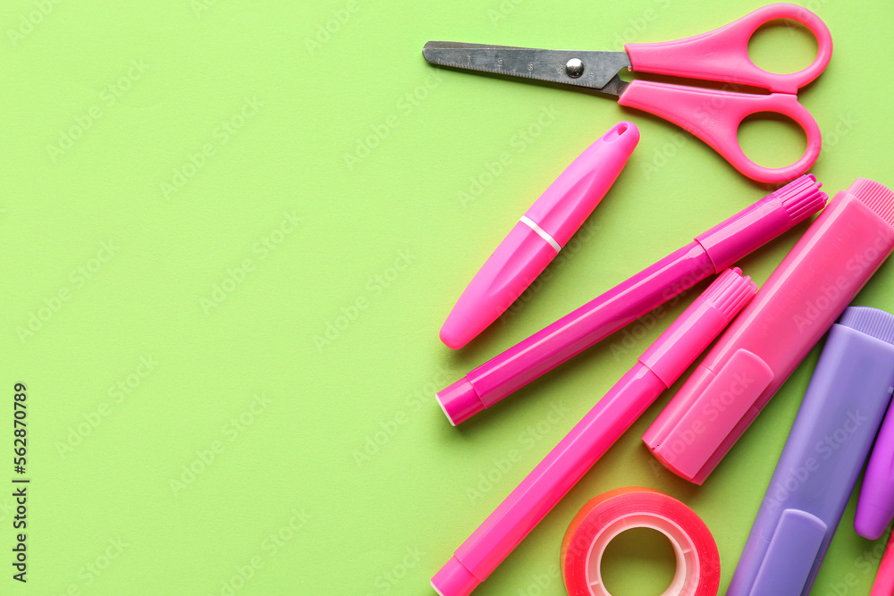 Set of stationery with scissors on green background