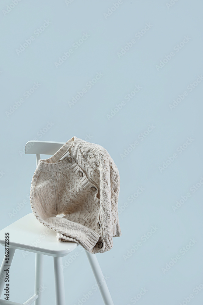 Chair with childrens cardigan on grey background