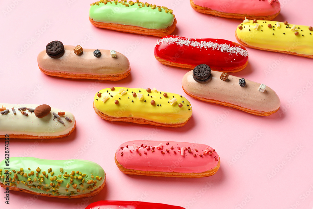 Many delicious glazed eclairs on pink background