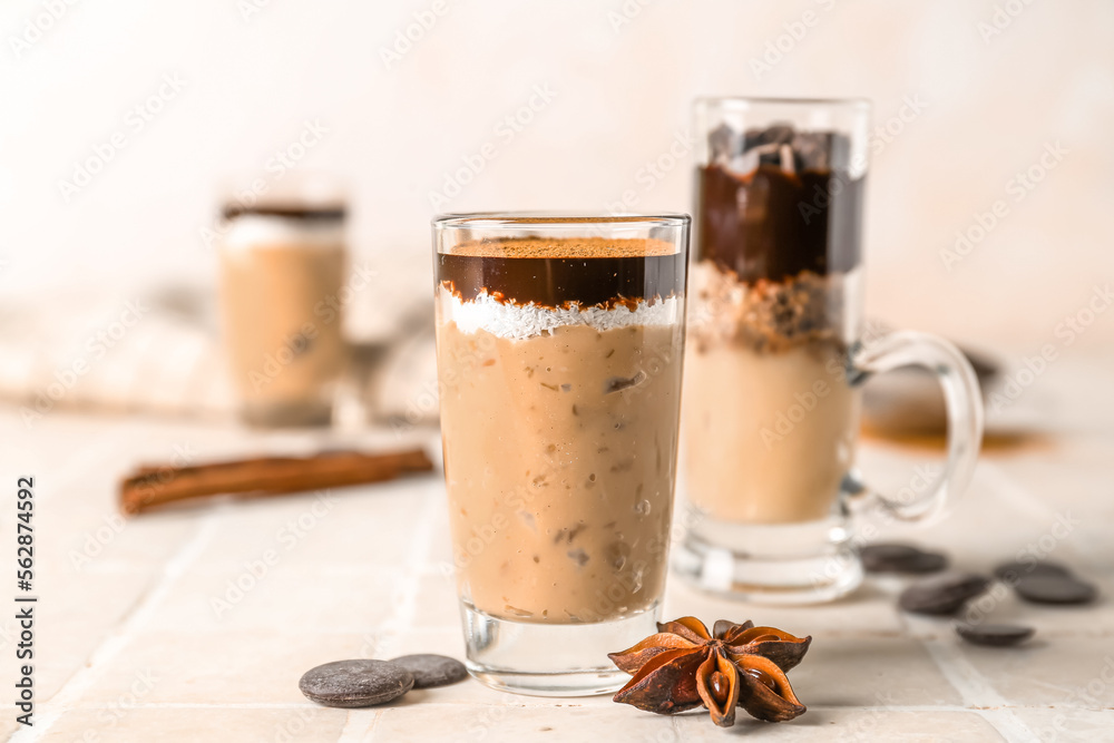 Shots of delicious pudding with cinnamon, anise and chocolate on tile table