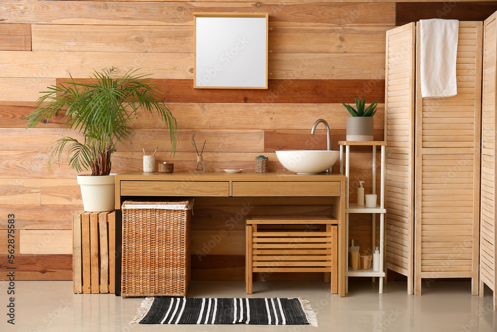 Interior of bathroom with sink, table and houseplants