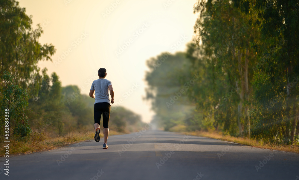 A man jogging alone through the road in morning.