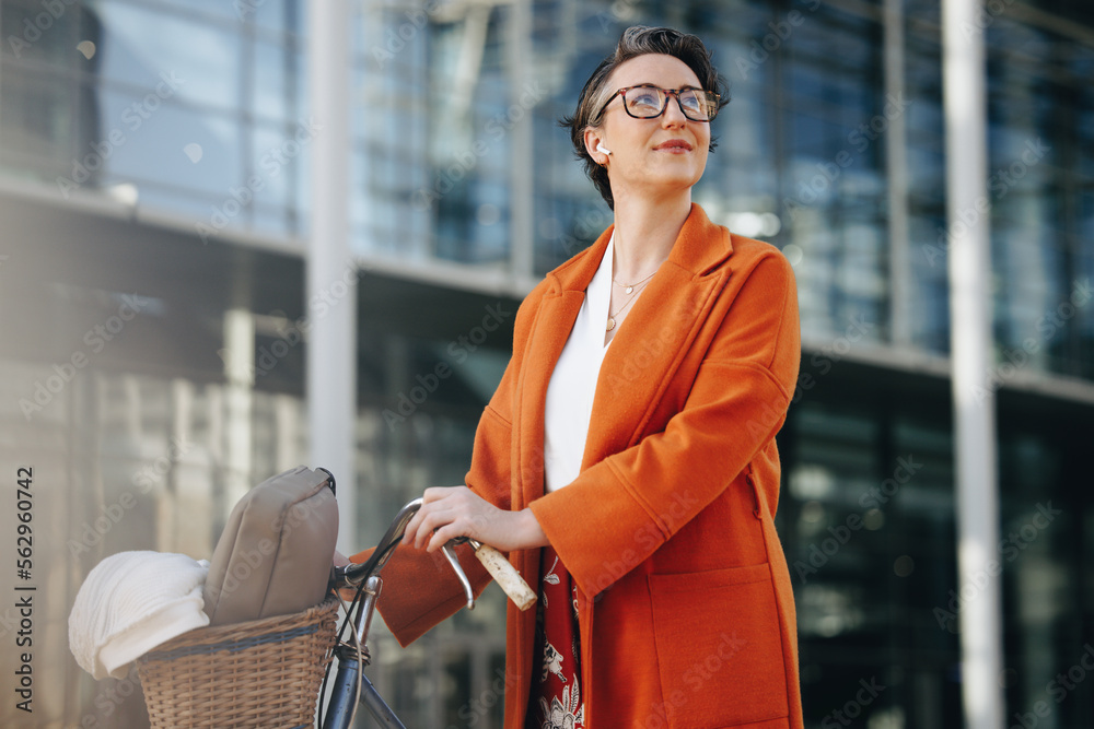 Pensive businesswoman pushing her bike during her morning commute in the city