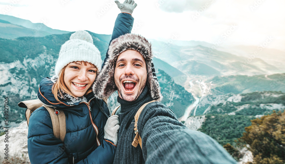 Happy couple of hikers taking selfie picture on top of the mountain - Two travelers with backpack sm