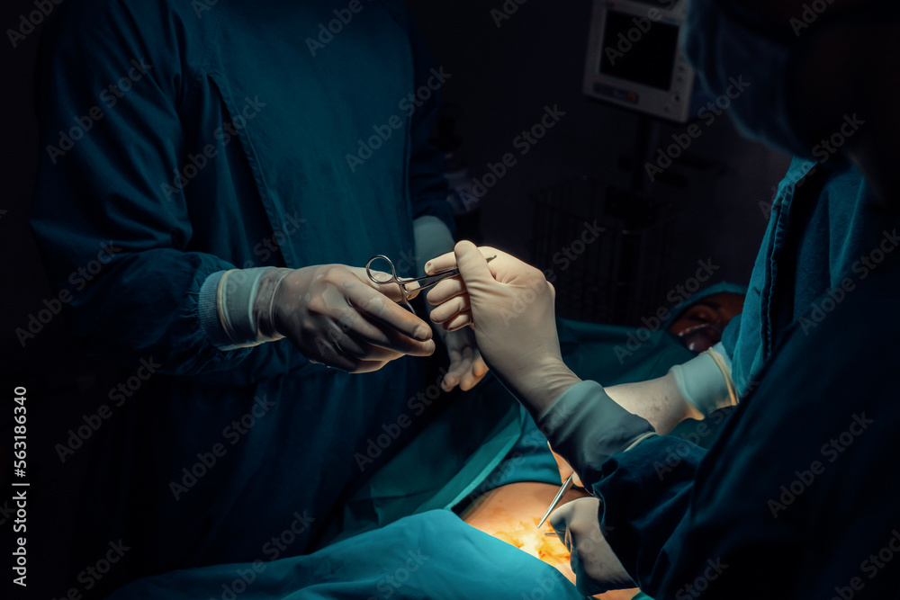 Image of surgical team perform surgery operation, nurse hand out sterile scissors to surgeon as supp