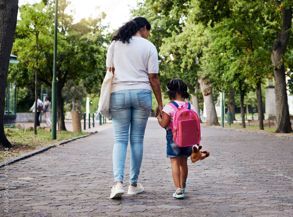 妈妈、孩子和背着背包手牵着手去学校，以确保户外公园的安全。妈妈