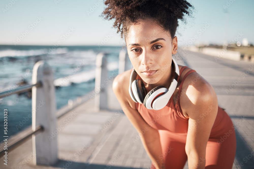 Portrait, exercise and black woman rest, beach and training outdoor, headphones and wellness. Africa