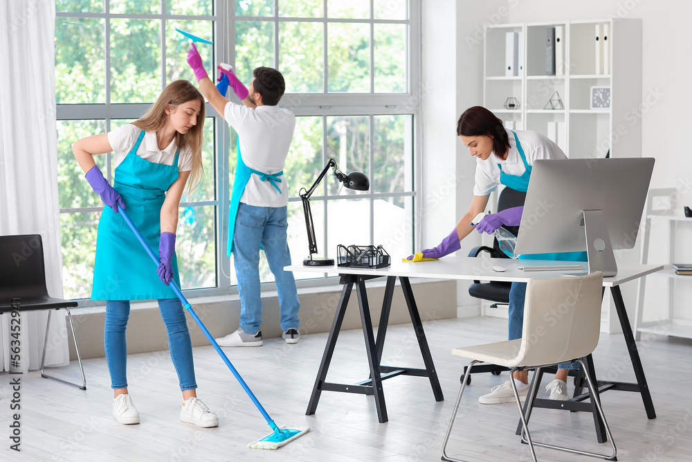 Young janitors cleaning in modern office