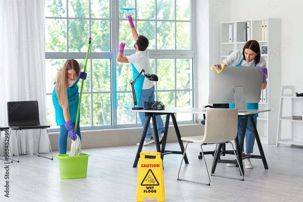 Young janitors cleaning in modern office