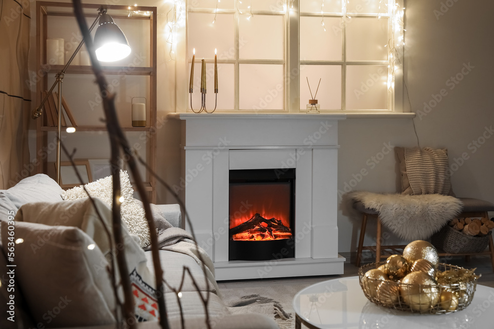 Interior of modern living room with electric fireplace, window and glowing lights